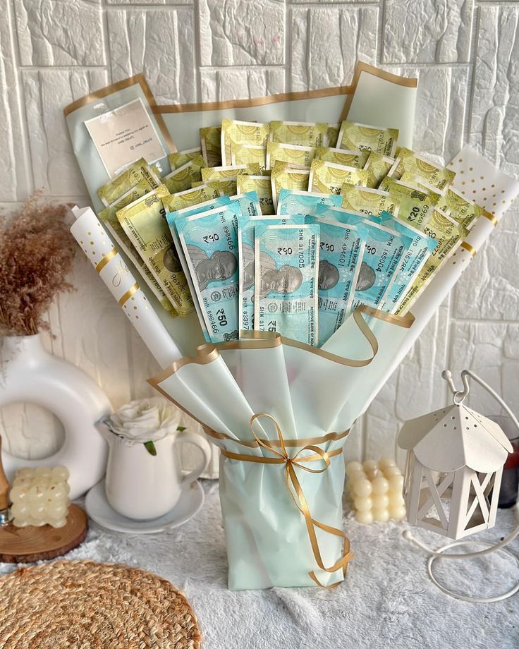 a vase filled with lots of money sitting on top of a white cloth covered table