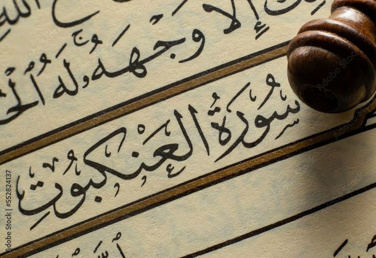 a wooden judge's gavel on top of an old book with arabic writing