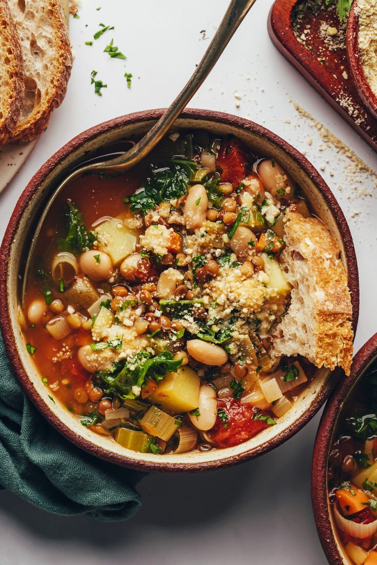 a bowl filled with soup next to some bread