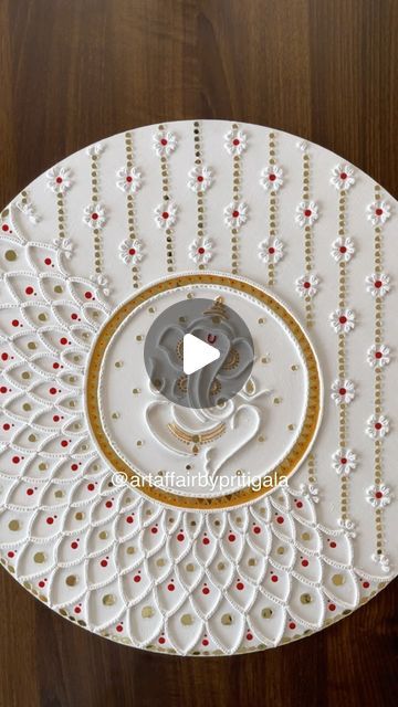 an intricately decorated white plate with red and gold accents