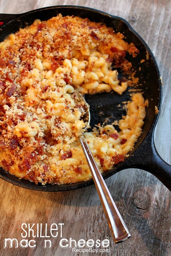 skillet macaroni and cheese with a spoon in it on a wooden table