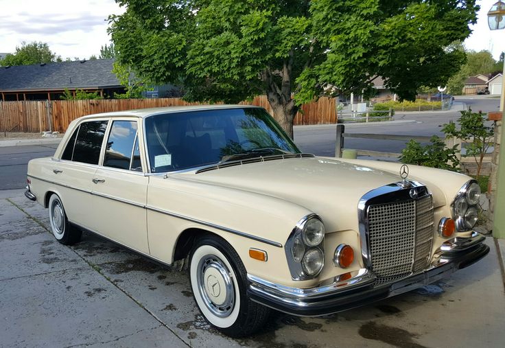 an old car is parked on the side of the road