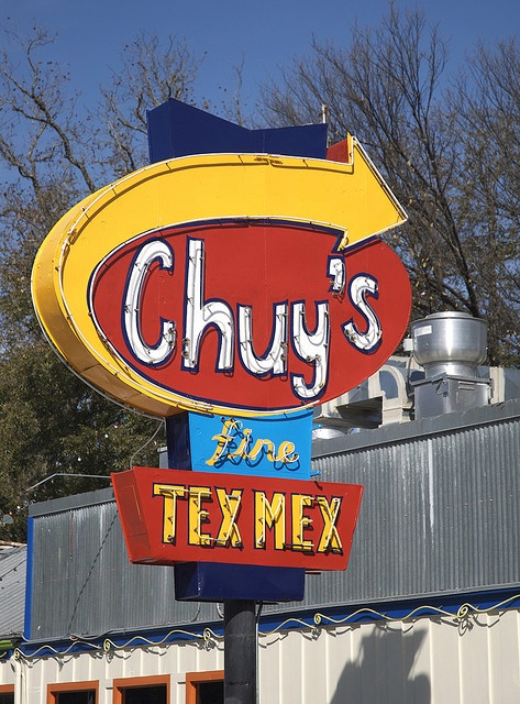 a sign for a tex - mex restaurant in front of a building that says chuy's