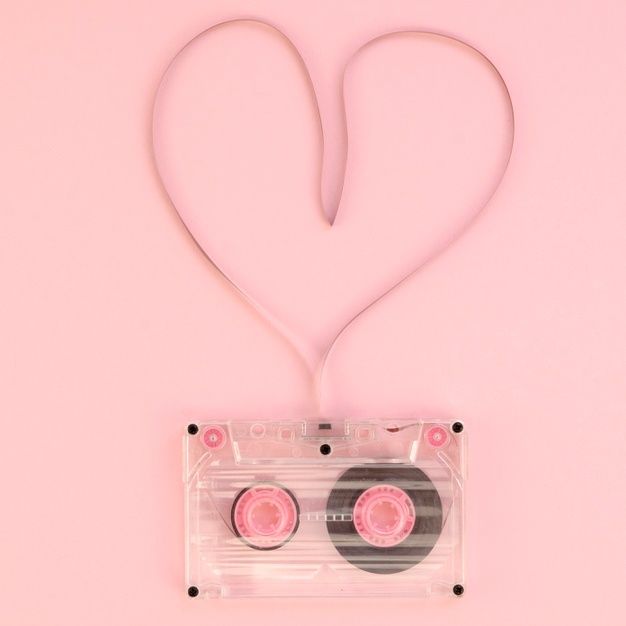 an audio cassette with two pink disks attached to it, in the shape of a heart