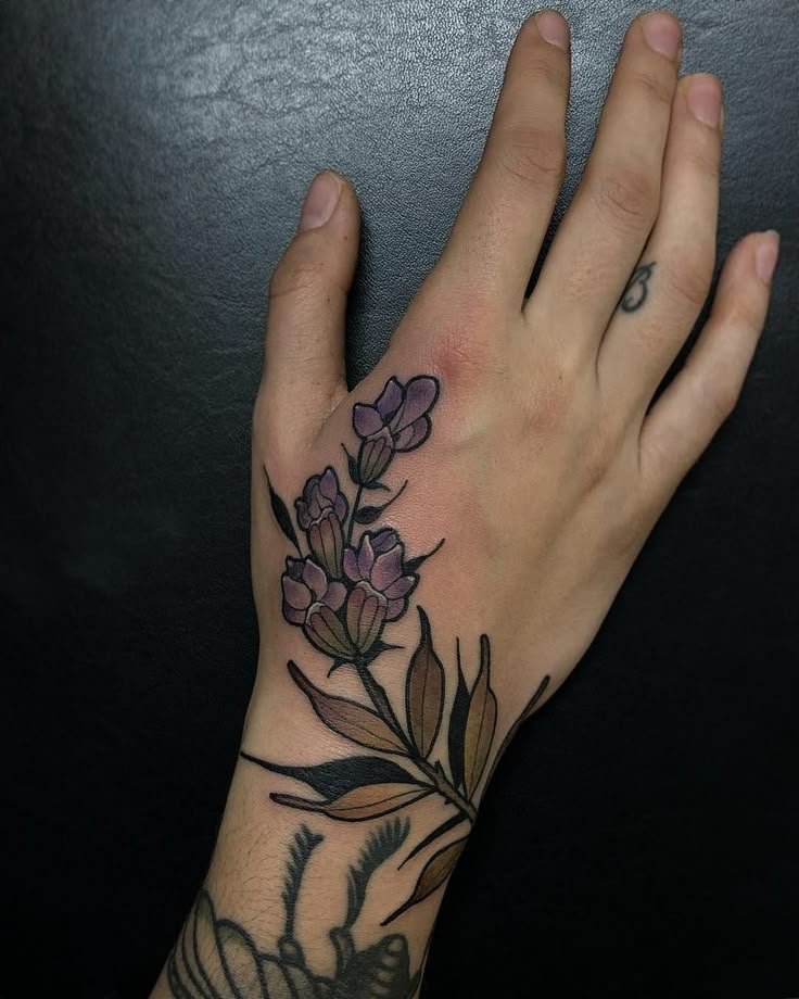 a person's hand with a flower tattoo on it