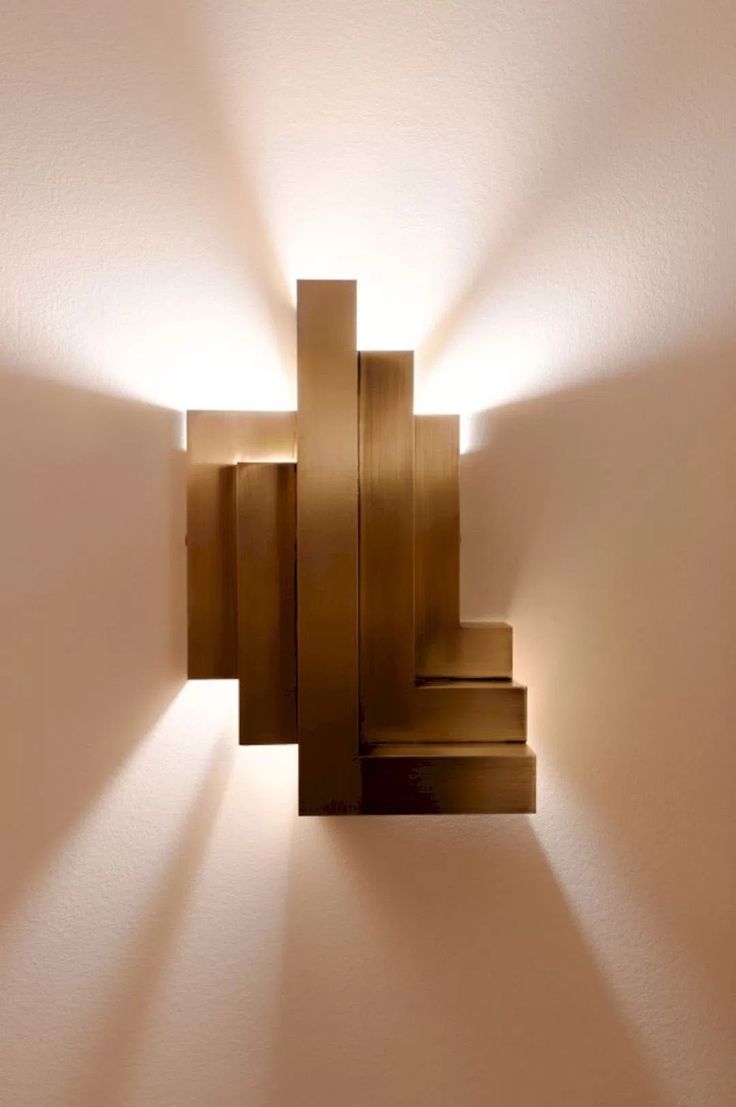 a wall light that is on the side of a wall with stairs in front of it