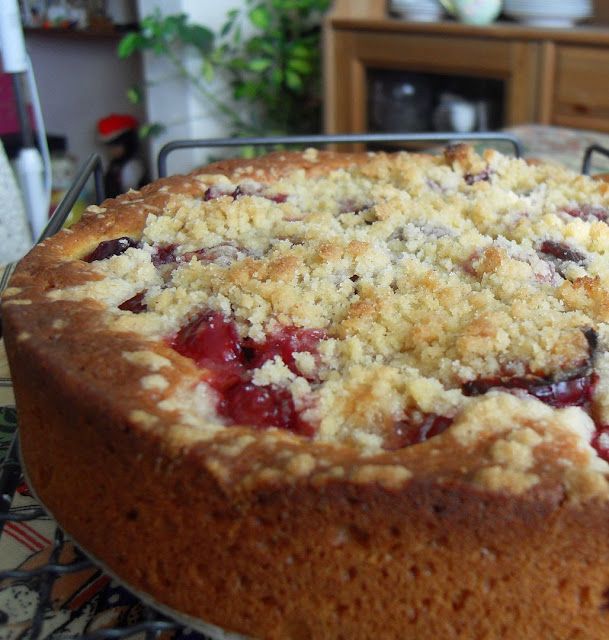 a cake sitting on top of a metal pan covered in crumbled toppings