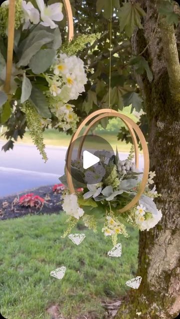 a tree with flowers hanging from it's branches and an image of butterflies in the background