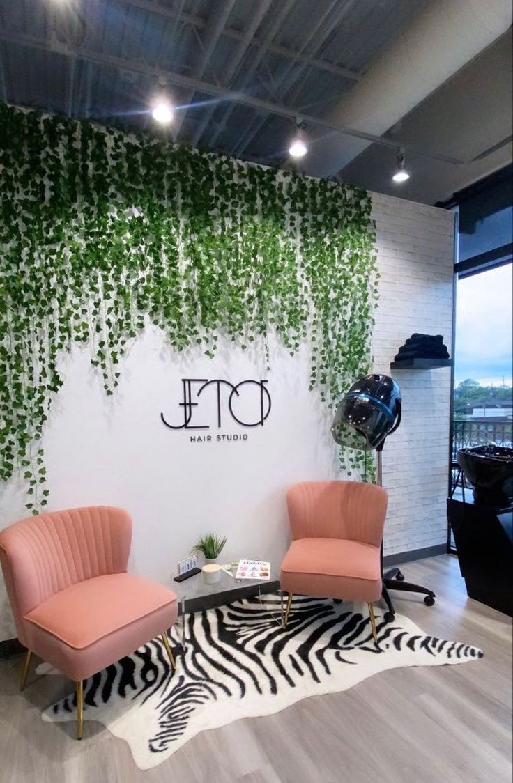 an office with two chairs and a zebra rug in front of the wall that has ivy growing on it