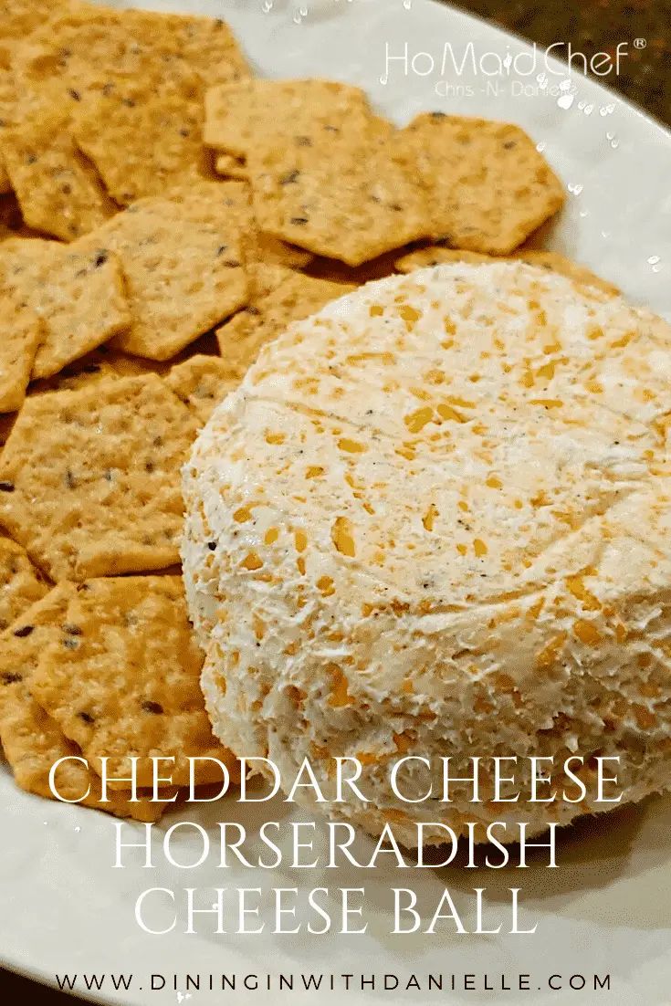 cheddar cheese horseradish cheeseball on a white plate with crackers