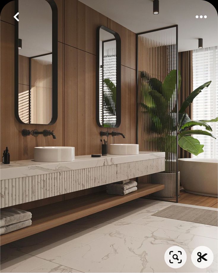 a bathroom with two sinks, mirrors and plants in the corner on the counter top