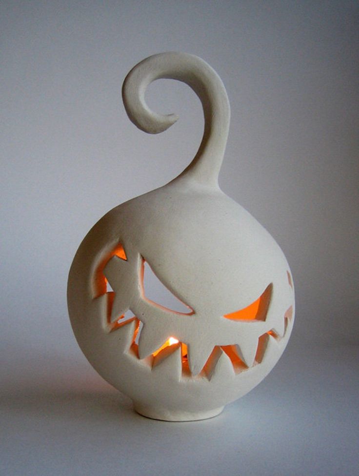 a white pumpkin shaped vase with glowing eyes