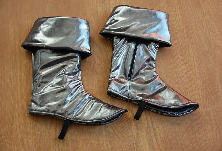 pair of shiny silver boots on wooden surface