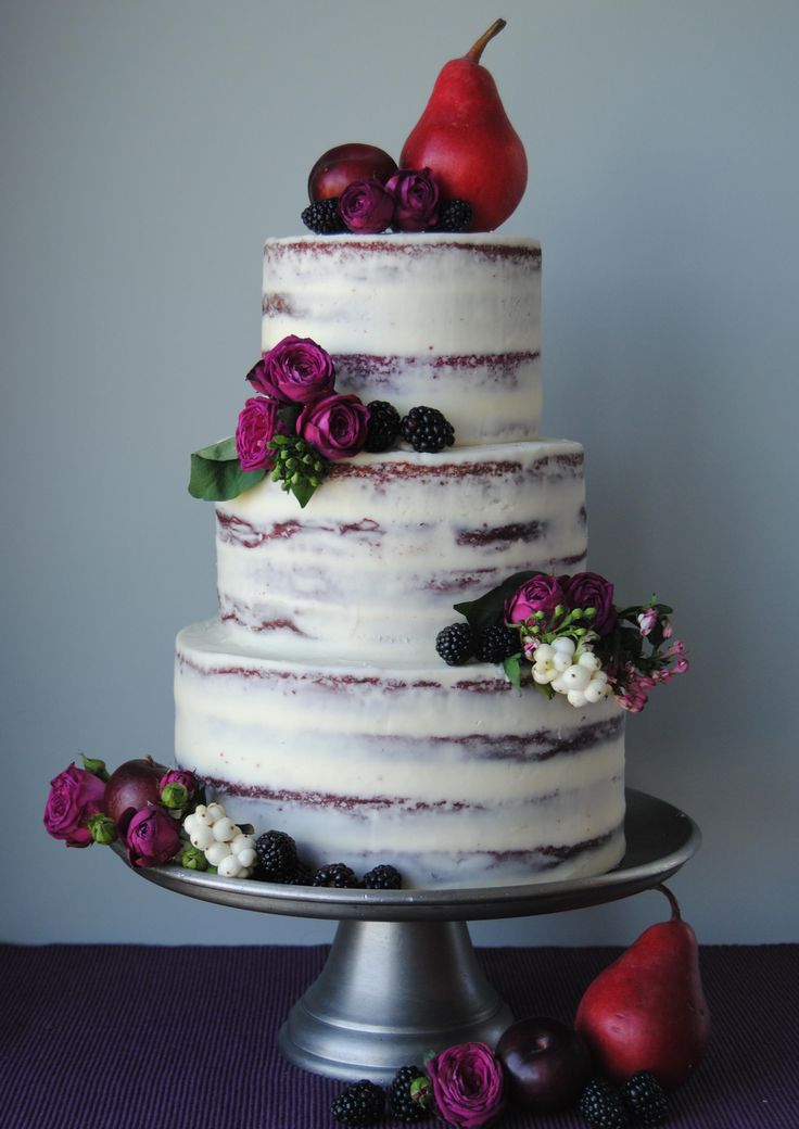 a three tiered cake with fresh fruit on top