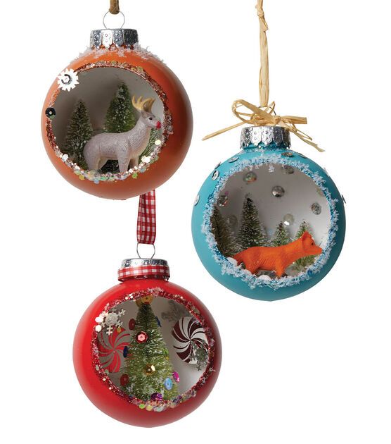 two christmas ornaments hanging from strings on a white background