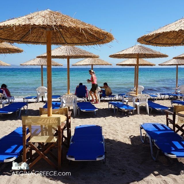 beach chairs and umbrellas are lined up on the sand