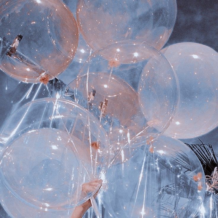 a woman is holding some balloons in her hand