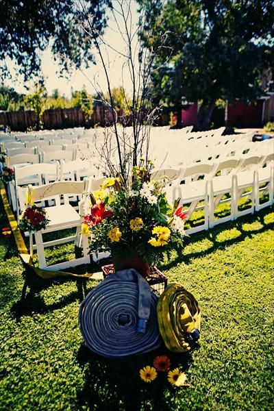 an outdoor ceremony setup with white chairs and flowers