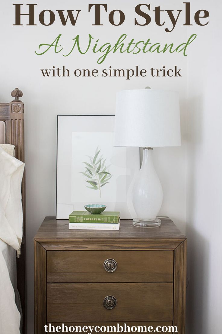 a nightstand with a lamp and pictures on it in front of a sign that says how to style a night stand with one simple trick