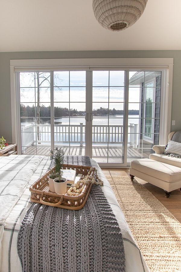 a bed with a tray on top of it next to a sliding glass door that leads outside