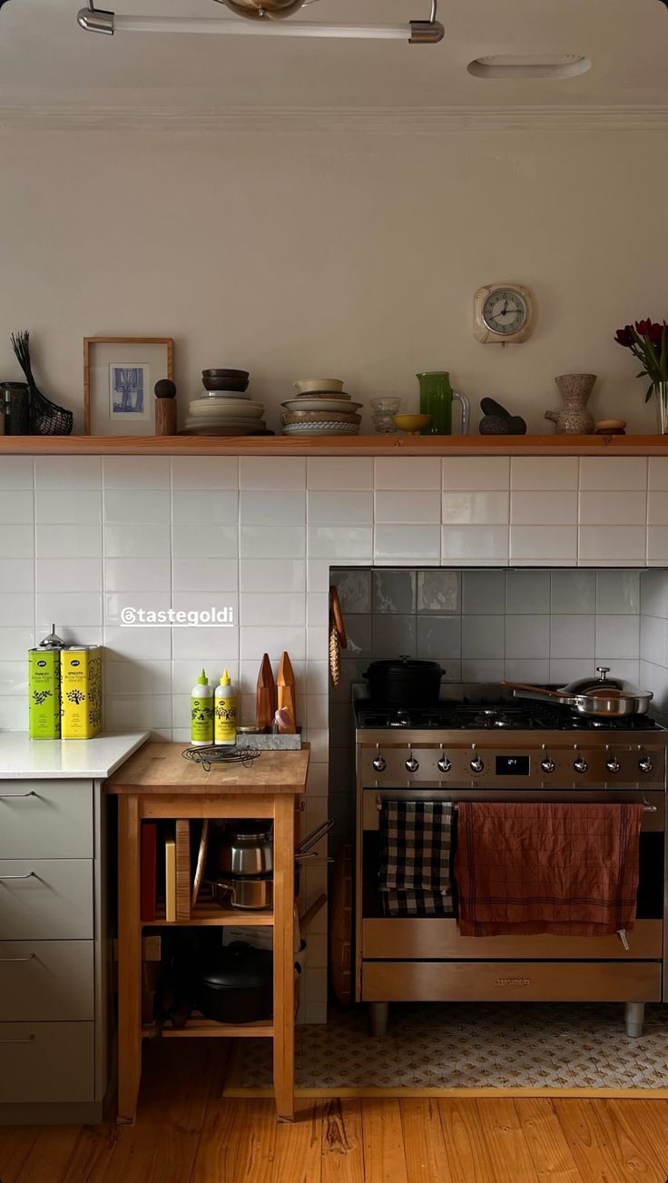 a stove top oven sitting inside of a kitchen next to a wooden table and counter