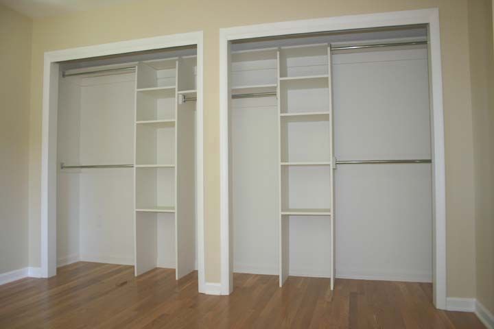 two empty white closets in an empty room