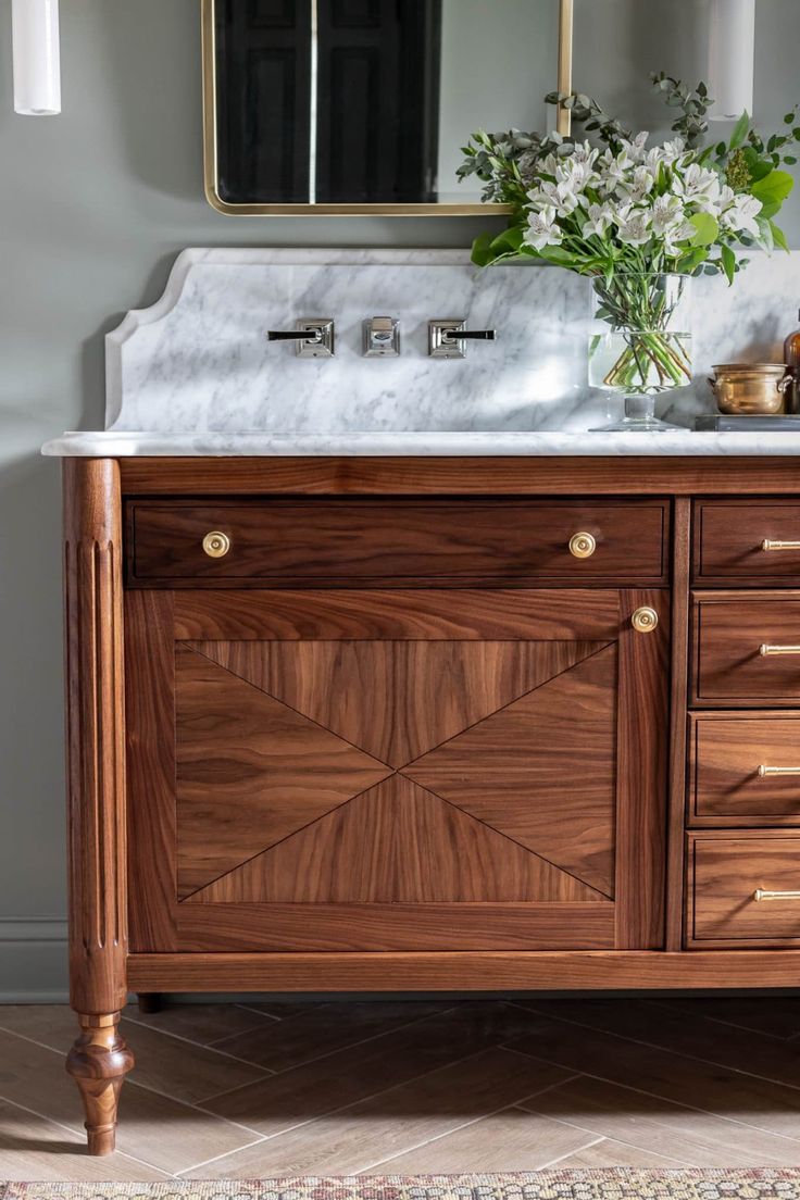 a bathroom vanity with marble top and wooden drawers