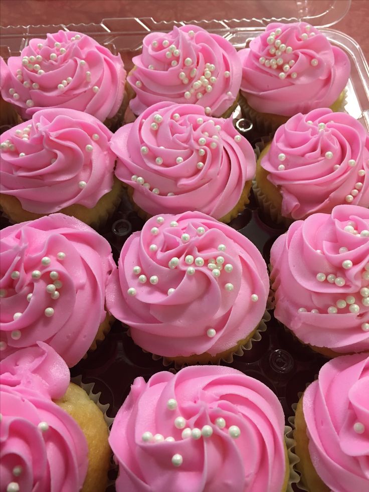 cupcakes with pink frosting and sprinkles in a plastic container