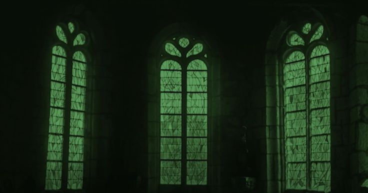 three windows with green light shining through them