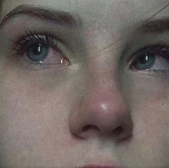 a close up of a woman's face with blue eyes