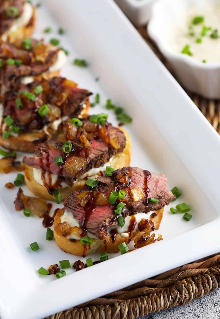 an appetizer is served on a white plate with onions and bacon, garnished with chives