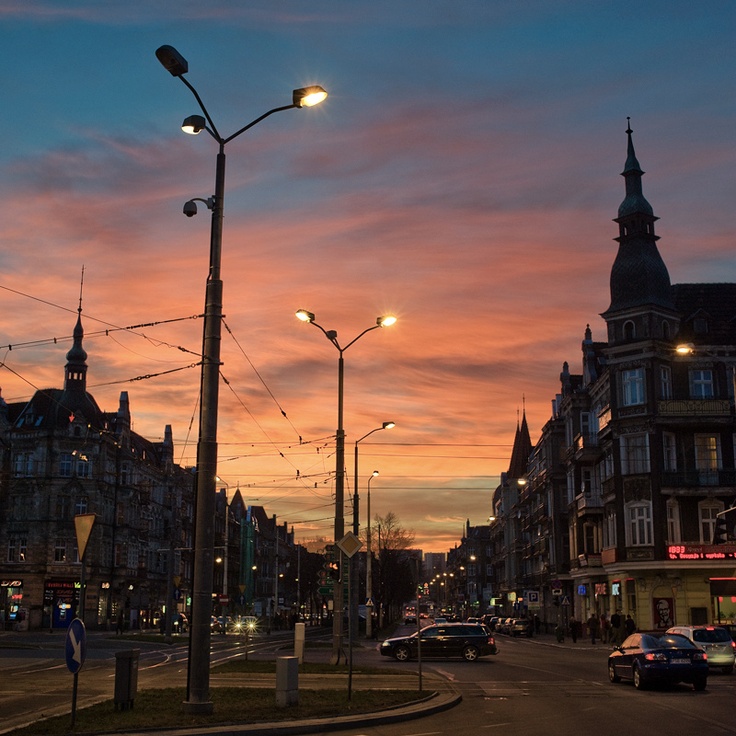 the sun is setting over a city street