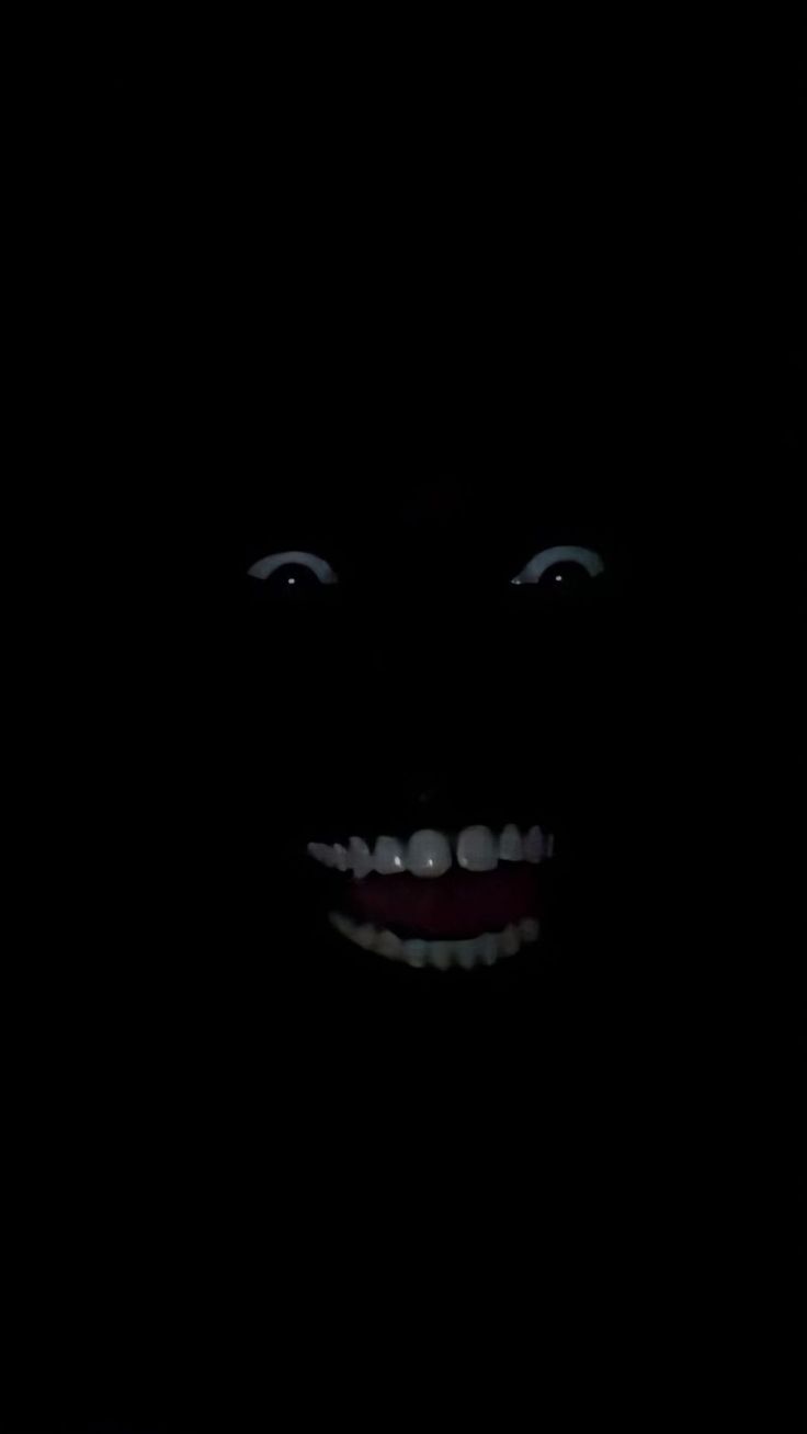 a creepy looking face in the dark with teeth and fangs on it's head