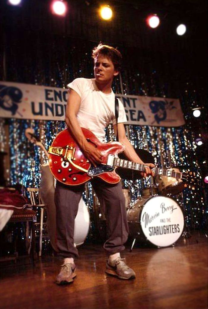 a young man is playing guitar on stage