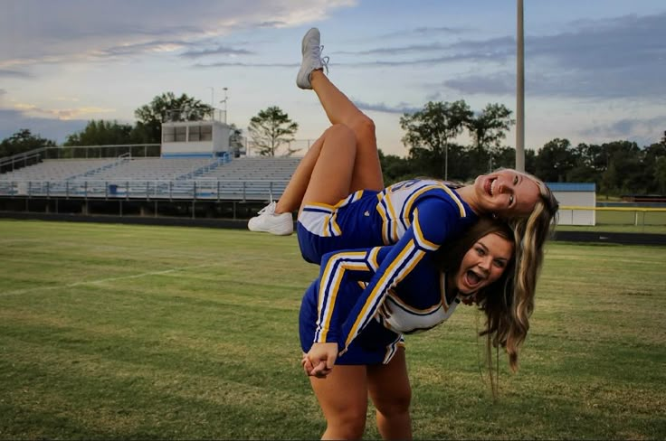 two cheerleaders are doing tricks on the field