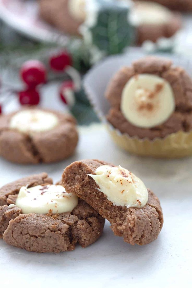 chocolate cookies with white frosting and cranberries in the background