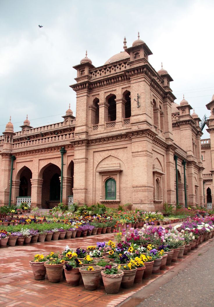 an old building with many potted plants in front of it and the words gulan khan on top