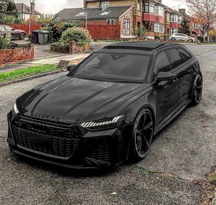 a black car parked in front of some houses