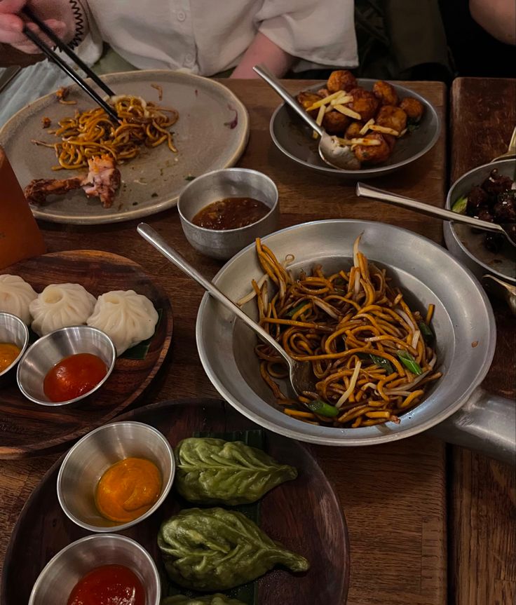 a table topped with bowls filled with different types of food next to chopsticks