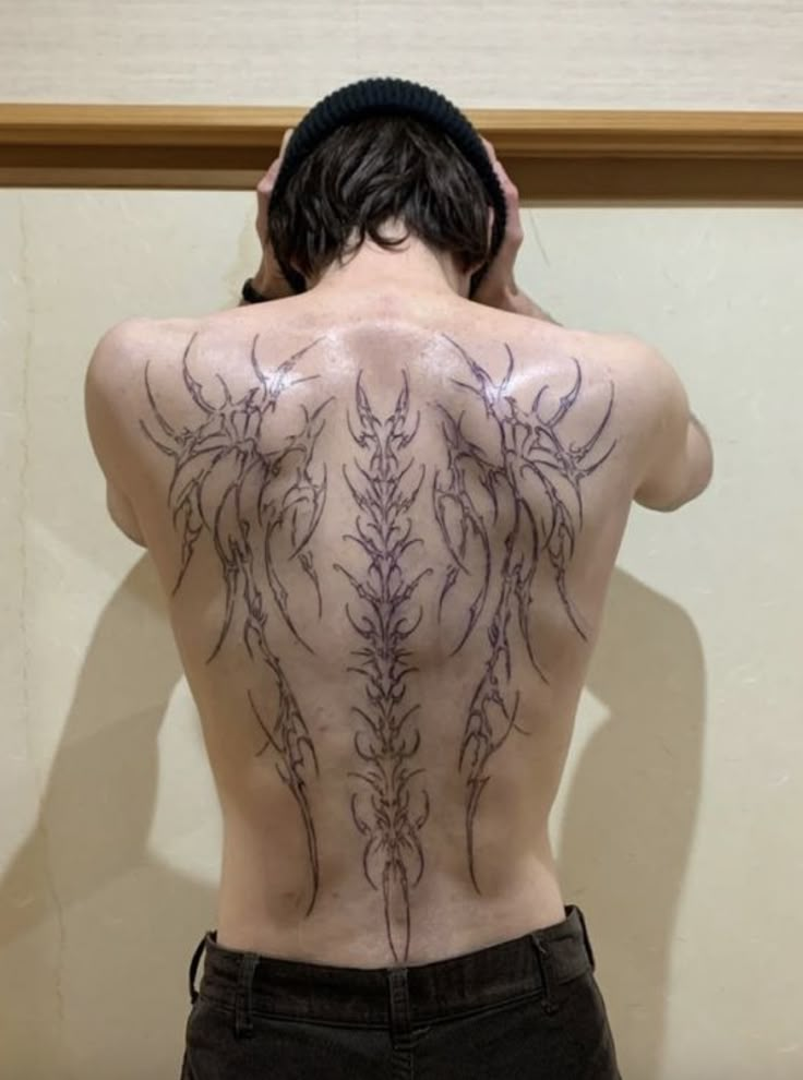 the back of a man with tattoos on his body