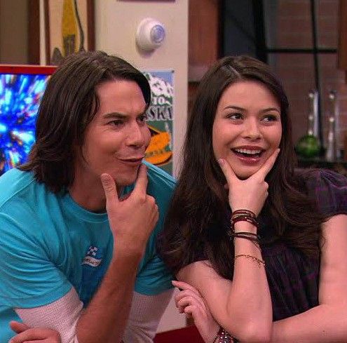 the young man and woman are posing for a picture in front of an orange frame