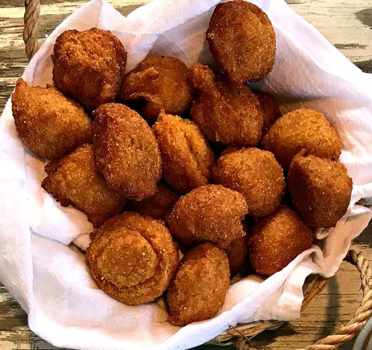 a basket filled with fried food on top of a wooden table