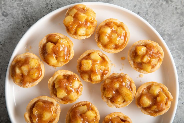 small pastries are arranged on a plate with caramel sauce drizzled over them