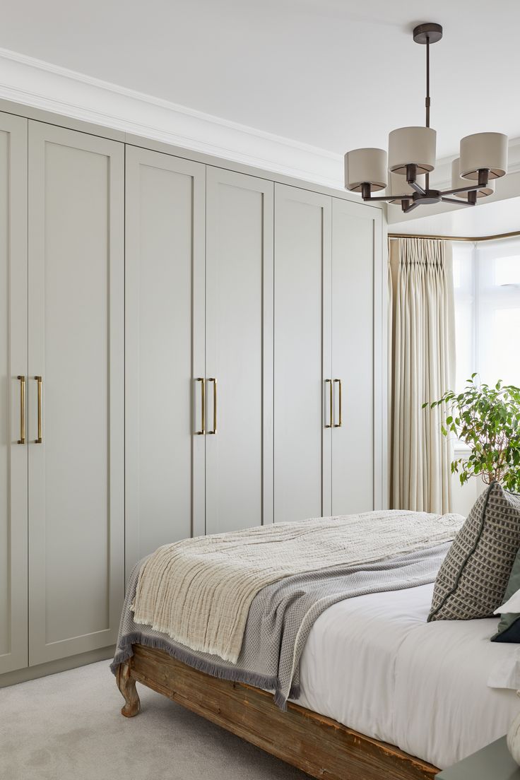 a bedroom with white walls and large closets in the corner, along with a bed that has two pillows on it