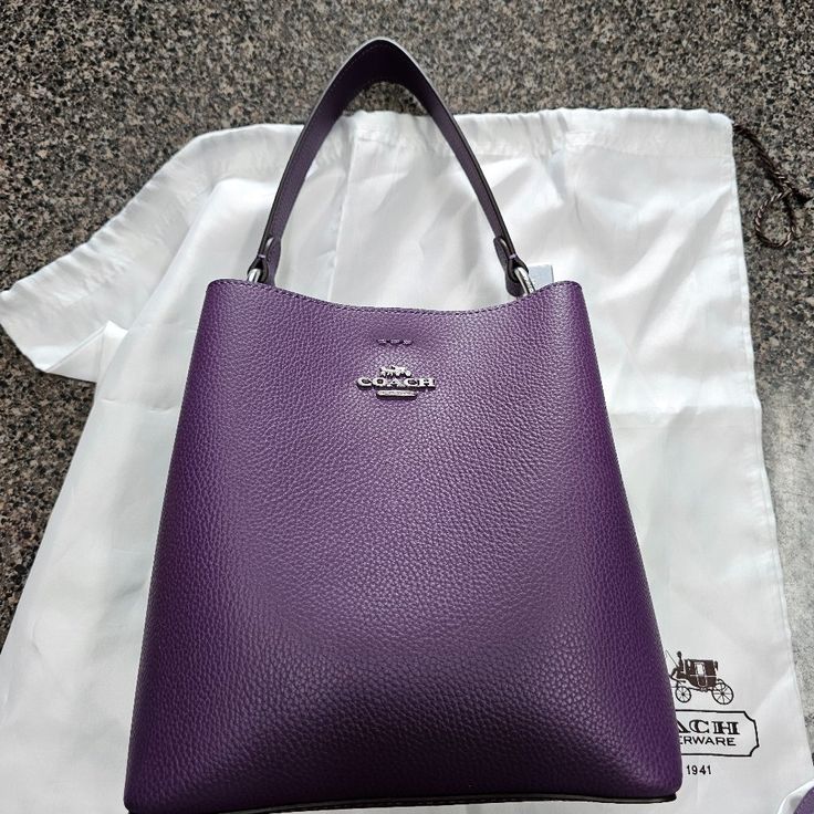 Never Used. Dust Bag And Strap Included. Designer Coach Bag In Purple, Luxury Purple Shoulder Bag With Removable Pouch, Classic Purple Evening Bag, Purple Travel Bag With Silver-tone Hardware, Coach Luxury Bucket Bag For Everyday, Purple Bucket Shoulder Bag With Detachable Strap, Classic Purple Shoulder Bag With Detachable Handle, Luxury Purple Shoulder Bag With Silver-tone Hardware, Chic Purple Bucket Bag For Everyday