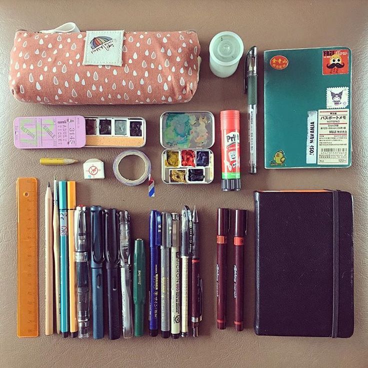 an assortment of pens, pencils, and other items laid out on a table