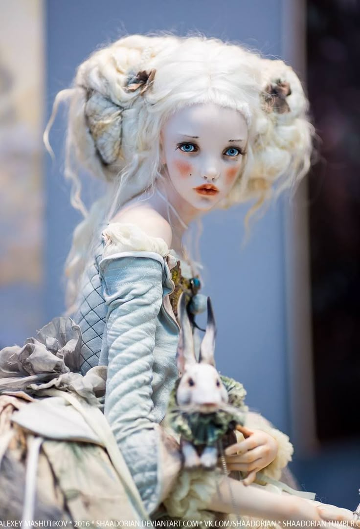 a doll with white hair sitting on top of a table