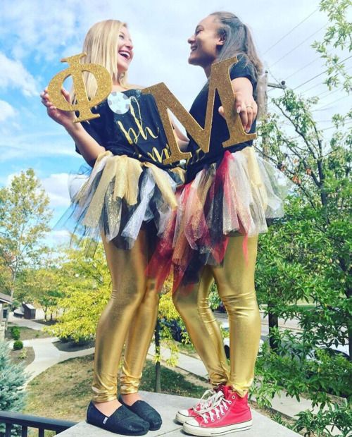 two girls dressed up in gold and black outfits with the word love spelled on them