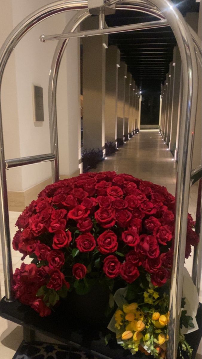 a bunch of flowers that are in a vase on a stand next to some stairs