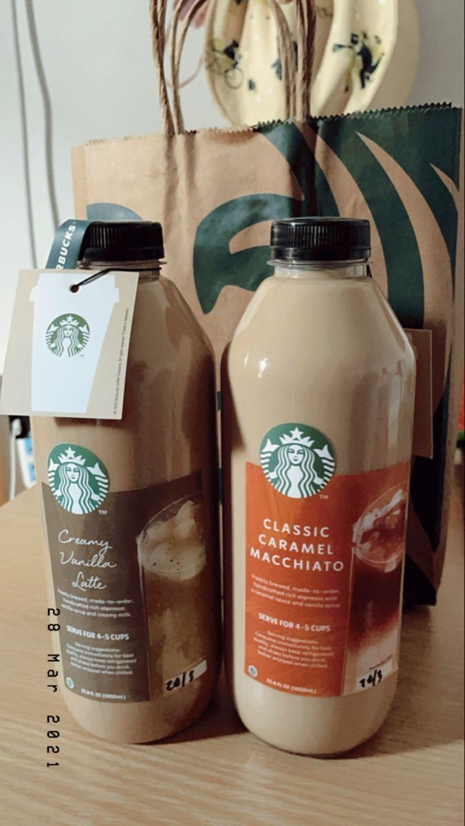 two bottles of starbucks coffee sit on a table